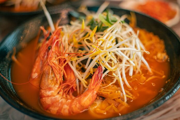 Photo by Ryoo Geon Uk a close up of a bowl of food with shrimp