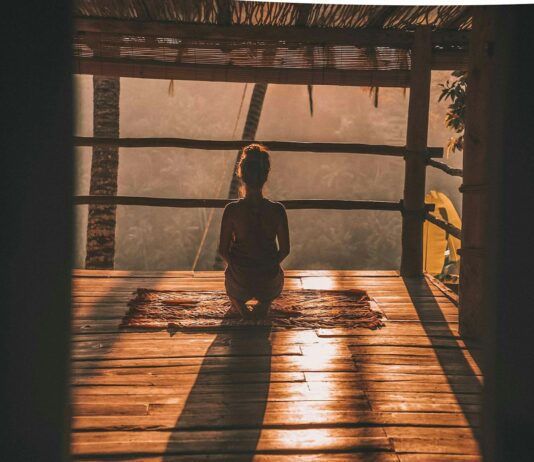 스트레스 해소를 위한 명상과 호흡법 woman meditating on floor with overlooking view of trees