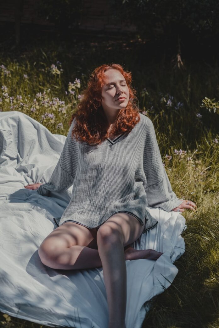 Photo by Faruk Tokluoğlu woman in gray sweater sitting on white textile