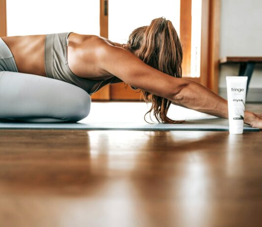 사무실에서의 스트레칭의 필요성 woman in gray sports bra and gray leggings lying on floor