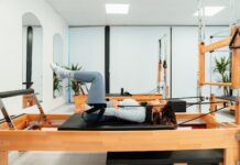 에너지 회복, 필라테스로 만성 피로 극복하기 a woman is doing a pivot on a pivot machine