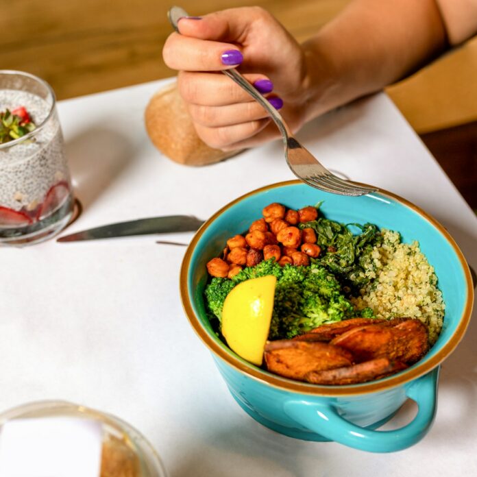 Photo by Farhad Ibrahimzade person holding spoon with food in blue ceramic bowl