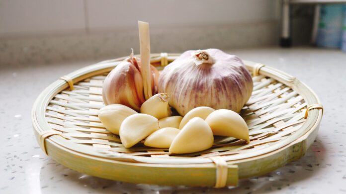 Photo by ji jiali a basket of garlic and garlic bulbs on a counter