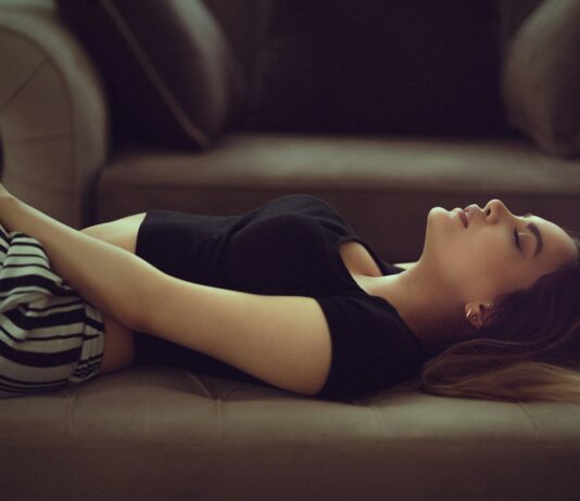 일상을 지배하는 만성피로, 원인과 극복 방법은? woman in black and white stripe shirt lying on brown couch