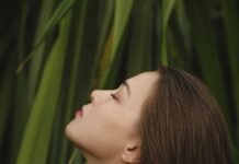 건강한 두피, 건강한 모발… 실생활에서 실천하는 ‘헤어 웰니스’ 트렌드 woman on front of green leaves