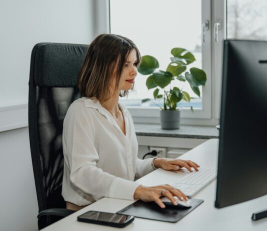 일과 삶의 균형을 잡는 여성 건강관리, 새 시대의 트렌드가 되다 a woman sitting at a desk using a computer