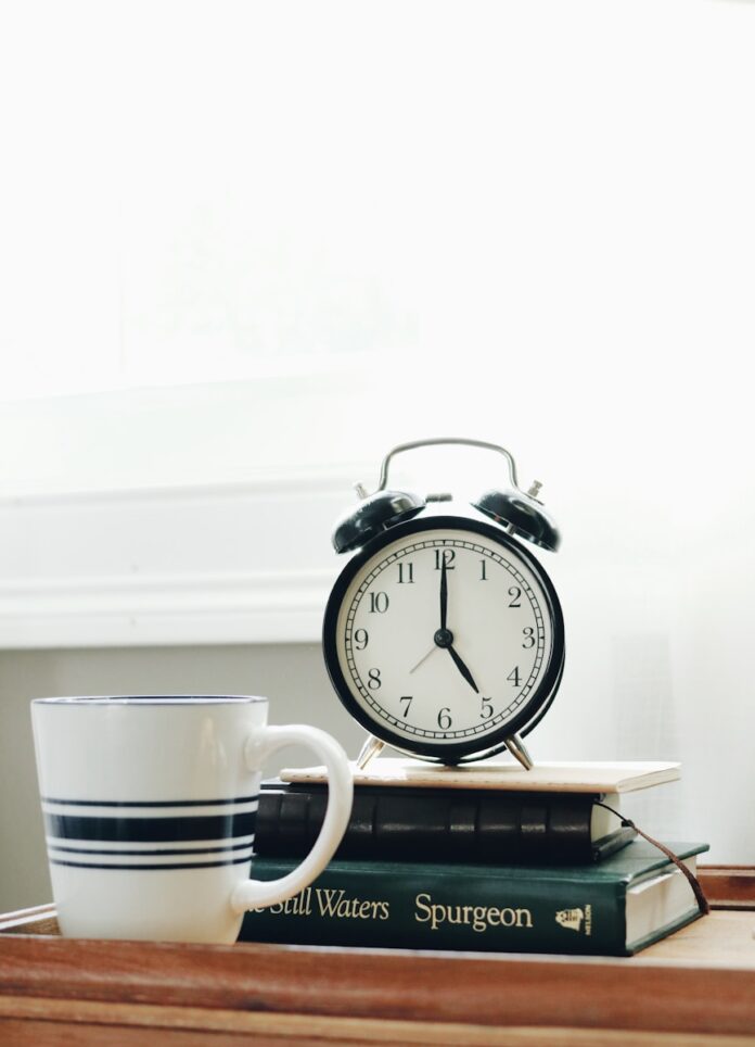 Photo by Jessica Mangano white ceramic mug beside white and black analog alarm clock
