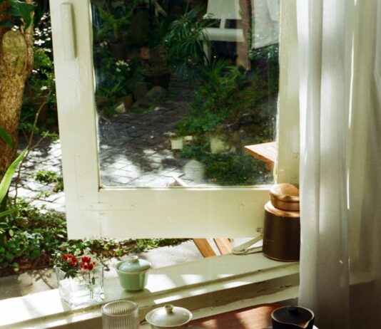 “마음도 건강하게” 일상 속 정신건강 지키는 새로운 트렌드와 실천법 Tea set arranged on a wooden tray by the window.