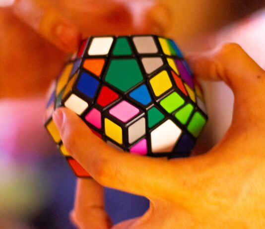 “뇌도 운동이 필요하다…일상 속 뇌건강 지키는 최신 트렌드와 실천법” person holding 3 x 3 rubiks cube