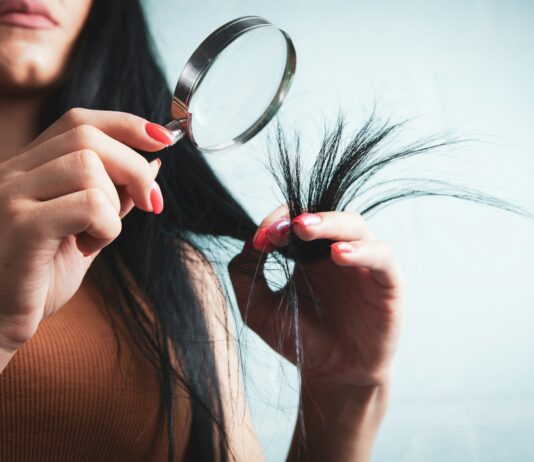 변화하는 헤어 건강 관리 트렌드, 일상 속에서 실천하는 방법 Woman examining split ends of hair with magnifying glass