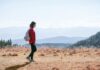 일과 건강, 균형 잡기…직장인을 위한 ‘마이크로 웰니스’ 실천법 a man with a backpack walking across a dry grass covered field